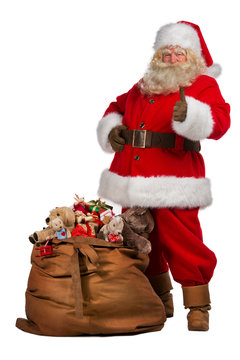 Santa Claus thumbs up near big bag full of gifts