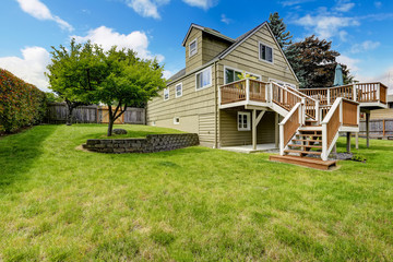 Brown walkout deck with white trim. Backyard view