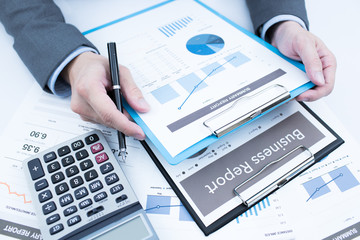 Close-up of graphs and charts analyzed by businessman