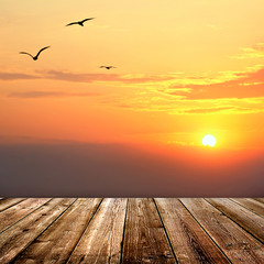 Naklejka na ściany i meble Sunset with seagulls and wood planks floor background