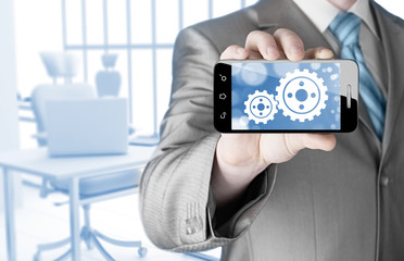 businessman show gear on smartphone to success concept