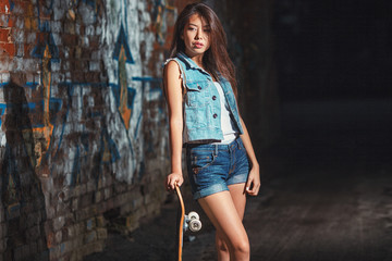 teen girl with skate board. Outdoors, urban lifestyle.