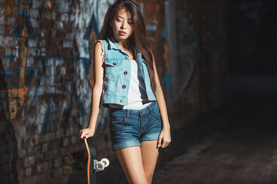 teen girl with skate board. Outdoors, urban lifestyle.