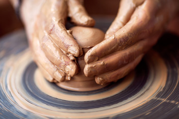 Hands working on pottery wheel