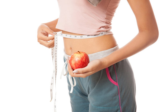 Waist of Asian healthy girl with measuring tape and apple