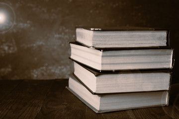 Antiquarian books on wooden table with warm light