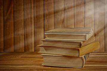 Antiquarian books on wooden table with warm light