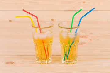 Two glasses full of apple juice.