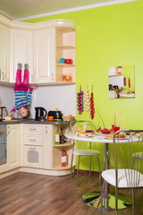 Little girl upside down sitting on shelves in kitchen