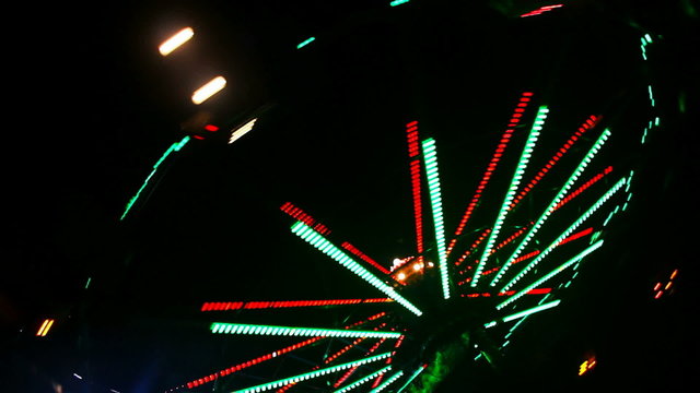 Amusement park at night, whirligig in motion
