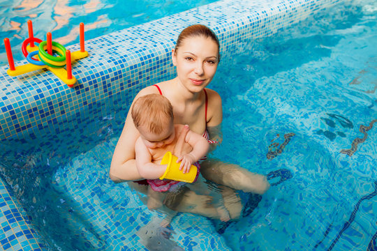 beautiful mother with a child in the pool. swimming for infants