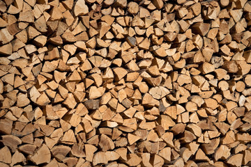 Photo of a stack of wood logs, wooden logs storage for winter, abstract background