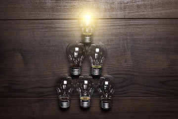 glowing bulb leadership concept on wooden background