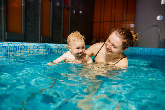 beautiful mother with a child in the pool. swimming for infants