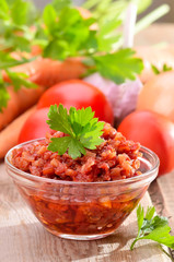 Tomato sauce in glass bowl on rustic wooden table