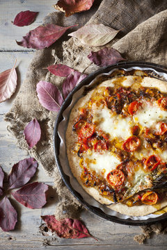 homemade rustic pizza on tray with autumnal leaves