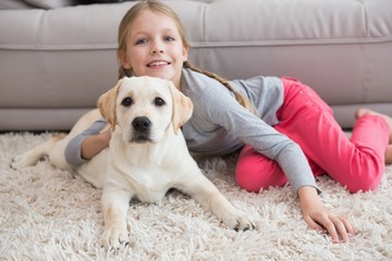 Cute little girl with her puppy on couch