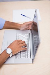 Hands using laptop at desk