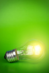 glowing light bulb over green background
