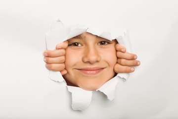 Cute little girl peeking through paper