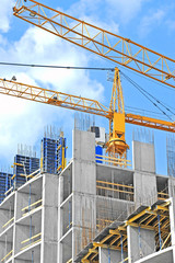 Crane and building construction site against blue sky