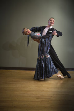 A man and woman dancing together in a dance studio. 