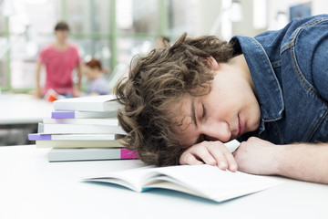Exhausted student sleeping in a university library