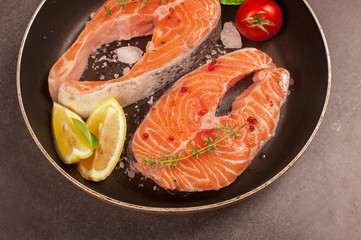 fresh salmon steak and ingredients for cooking on a grill pan