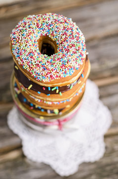 Stack of three doughnuts decorated with sugar granules, elevated view