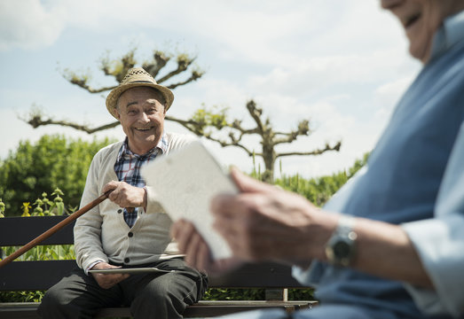 Germany, Worms, Two old men using tablet computers in the park