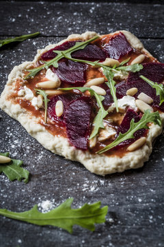Mini pizza with beetroot, rucola and pine nuts