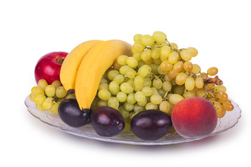 Glass dish with grapes, plums, peaches, bananas and apples