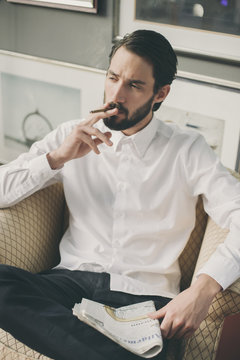 Portrait of young man smoking cigarillo