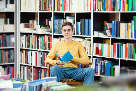 Young man reading in a library 