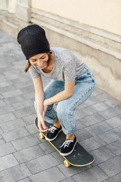 Smiling young female skate boarder on her skateboard