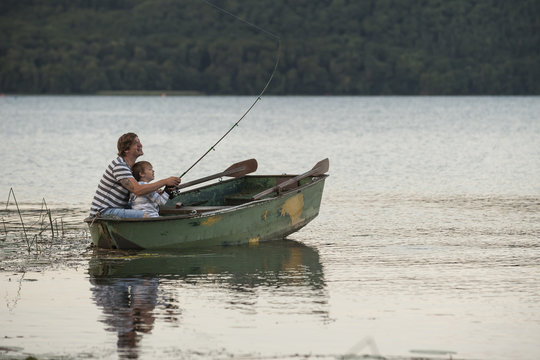 Germany, Rhineland-Palatinate, Laacher See, father and son fishing from boat - Powered by Adobe