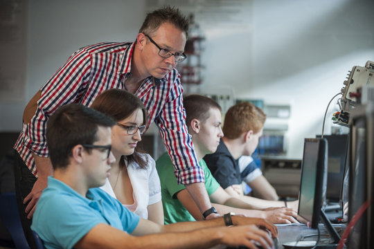 Vocational school students with teacher in computer lab