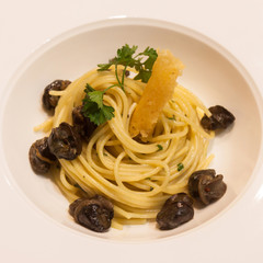 Spaghetti with snails and sauce in a dish