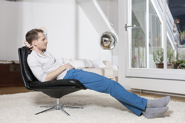 Man relaxing in armchair after work