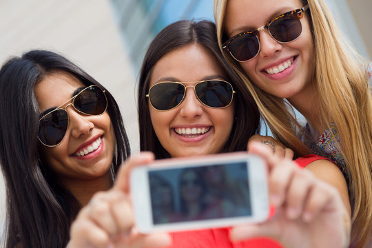 Three friends taking photos with a smartphone