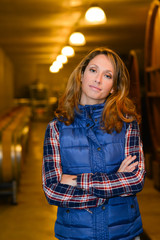 cheerful young woman oenologist tasting wine in cellar