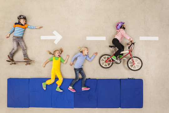 Children cycling, skateboarding and running in the street