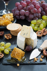 Camembert with fresh honey, grapes and nuts, vertical