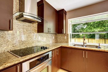 Modern kitchen room with matte brown cabinets and granite trim. - obrazy, fototapety, plakaty
