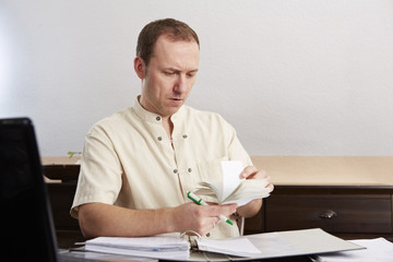Mann bei der Buchführung, Rechnungen prüfen