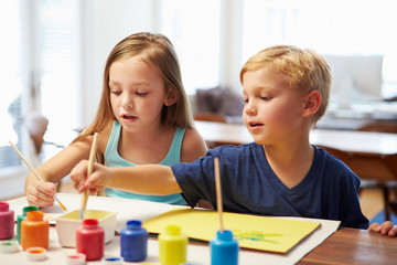 Two Children Painting Picture At Home