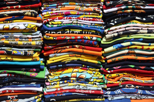 magliette di cotone impilate l'una sull'altra pronte per essere vendute ai turisti. Ottima fattura, colori brillanti e vivaci per prodotti per vestire bambini, adulti e anche anziani