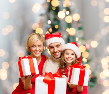 happy family in santa helper hats with gift boxes - Powered by Adobe