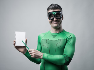 Cheerful superhero with notebook