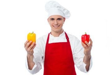 Chef in uniform showing capsicums